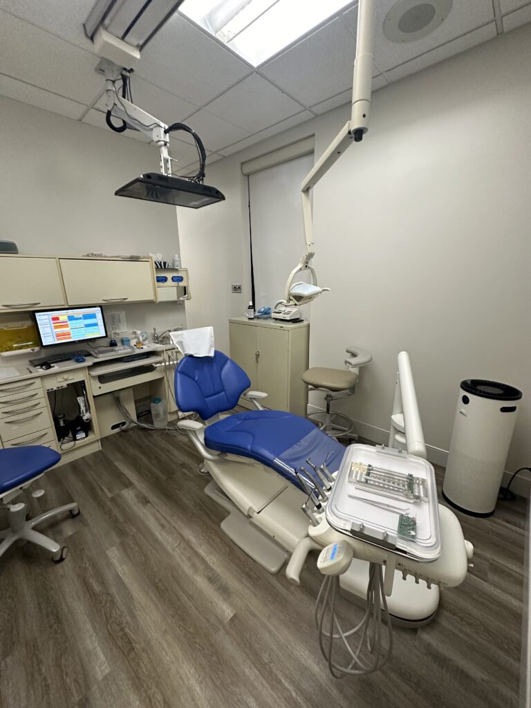 Treatment room at Simcoe Smile Dental with a blue chair and overhead TV